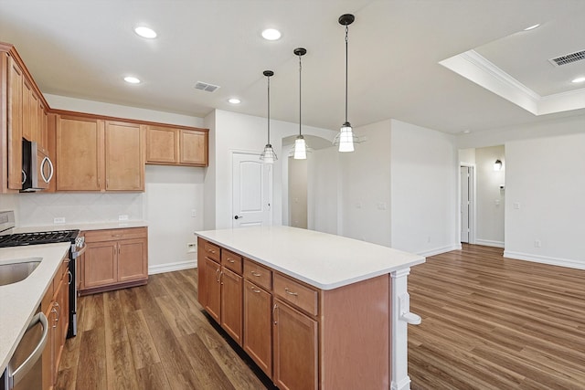 kitchen featuring pendant lighting, ornamental molding, a kitchen island, dark hardwood / wood-style flooring, and stainless steel appliances