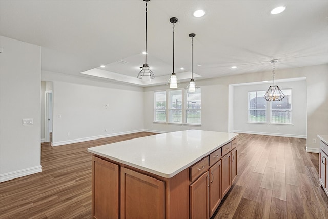 kitchen with a center island, dark hardwood / wood-style floors, decorative light fixtures, and a notable chandelier