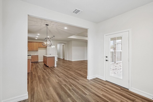 kitchen featuring dark wood-type flooring, a center island, and hanging light fixtures