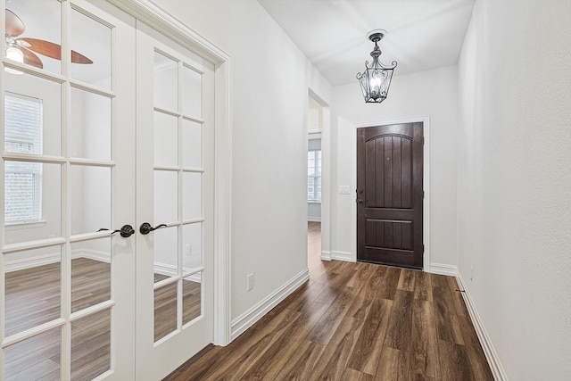 interior space with dark hardwood / wood-style floors, a notable chandelier, and french doors