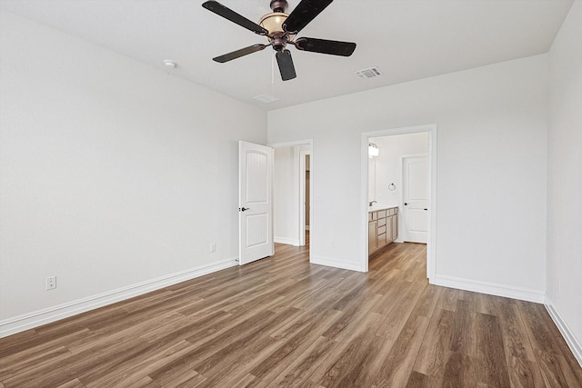 unfurnished bedroom with ensuite bath, ceiling fan, and hardwood / wood-style floors