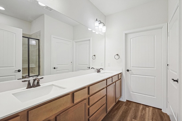 bathroom with an enclosed shower, hardwood / wood-style floors, and vanity