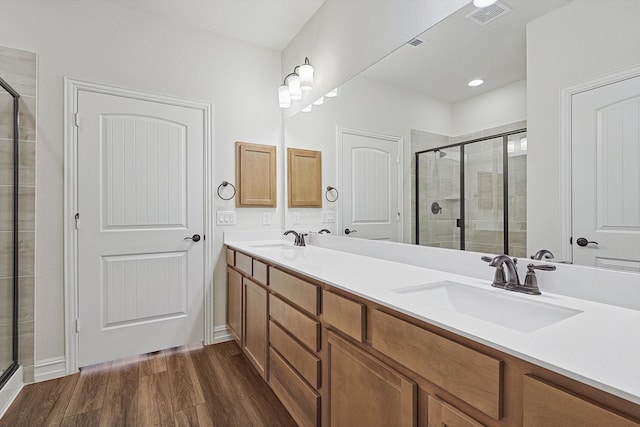 bathroom with an enclosed shower, vanity, and wood-type flooring