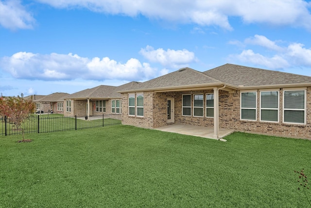 rear view of house with a lawn and a patio