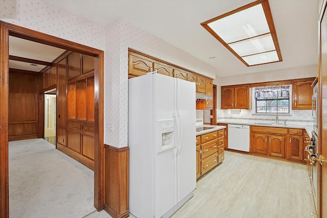 kitchen featuring sink, white appliances, and light hardwood / wood-style floors