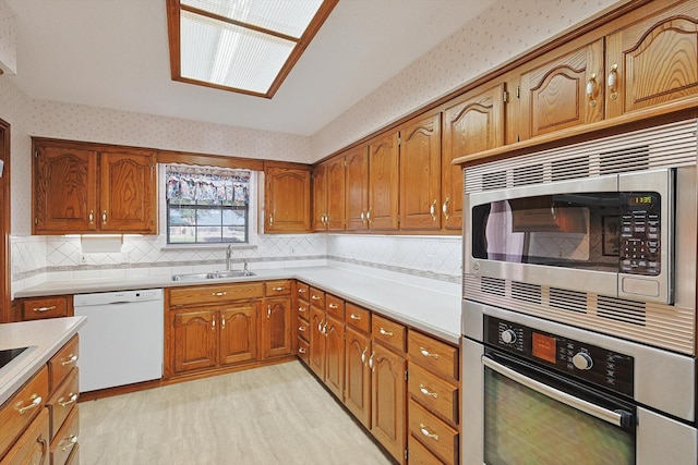 kitchen featuring sink, decorative backsplash, stainless steel appliances, and light hardwood / wood-style floors