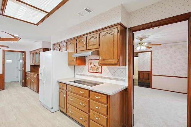 kitchen with black electric stovetop, white fridge with ice dispenser, and ceiling fan