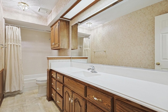 full bathroom featuring vanity, toilet, a textured ceiling, and shower / bath combo with shower curtain