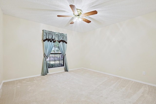 unfurnished room featuring ceiling fan, light carpet, and a textured ceiling