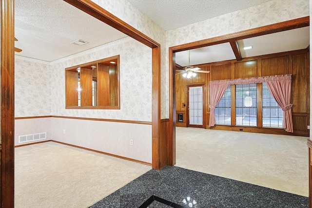 unfurnished room featuring ceiling fan, carpet flooring, and a textured ceiling