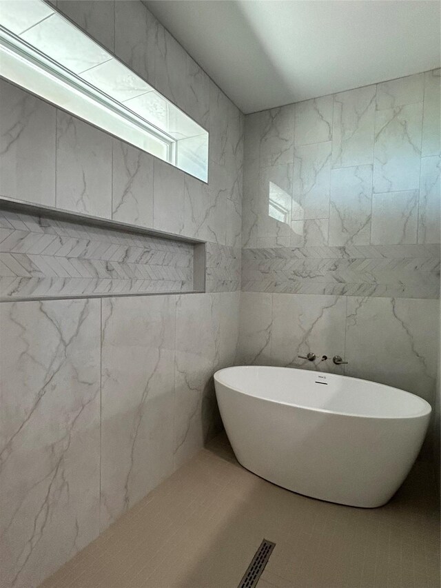 bathroom featuring a bathtub and tile walls