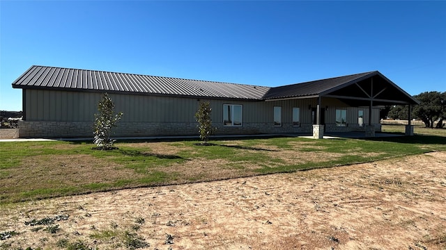 back of property with a lawn and a carport