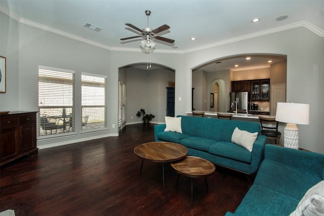 living room with ceiling fan, dark hardwood / wood-style flooring, sink, and ornamental molding