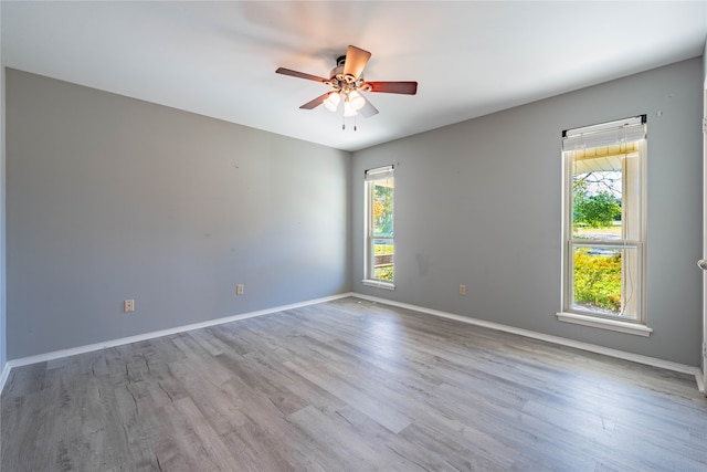 unfurnished room with a wealth of natural light, light hardwood / wood-style flooring, and ceiling fan