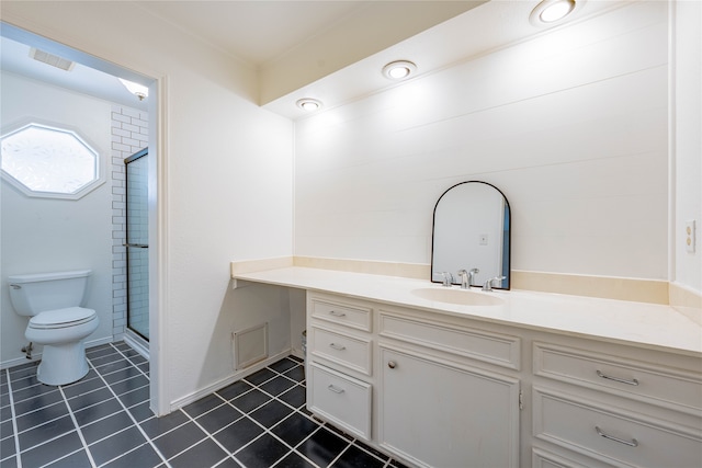 bathroom with tile patterned floors, vanity, toilet, and a shower with shower door