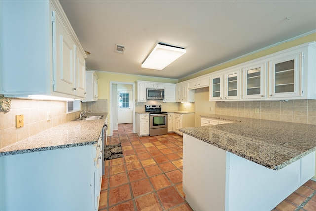 kitchen with kitchen peninsula, backsplash, stainless steel appliances, sink, and white cabinets