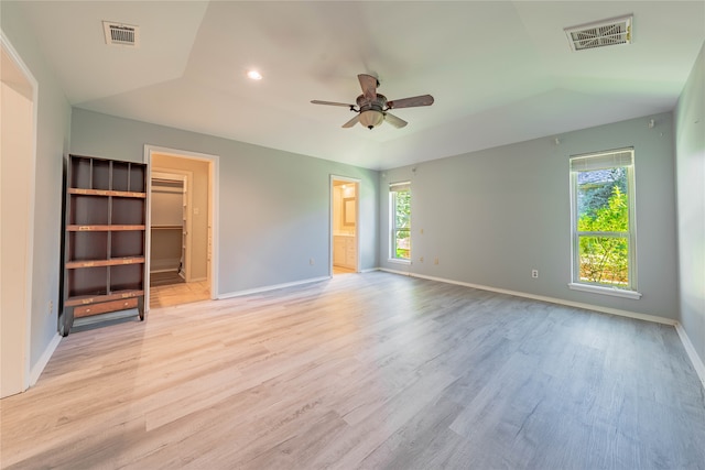 unfurnished bedroom featuring lofted ceiling, ceiling fan, a spacious closet, connected bathroom, and light hardwood / wood-style floors