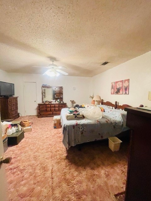 carpeted bedroom featuring ceiling fan and a textured ceiling