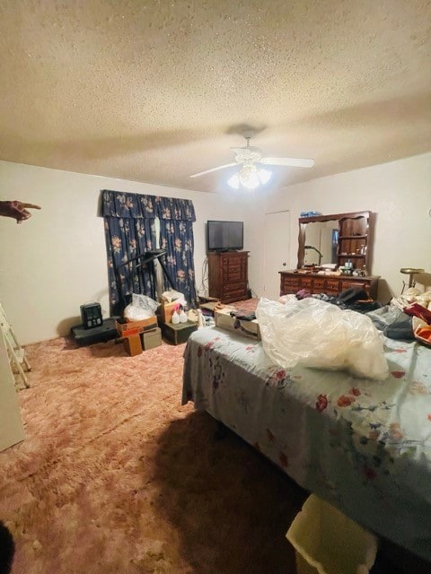 bedroom featuring ceiling fan, carpet floors, and a textured ceiling