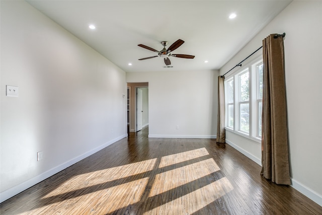 unfurnished room featuring ceiling fan and dark wood-type flooring