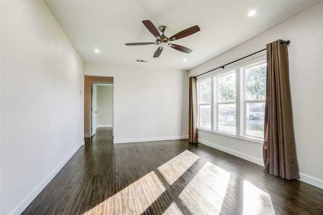 empty room with ceiling fan and dark wood-type flooring