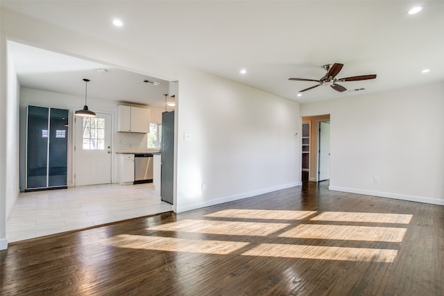 unfurnished living room with ceiling fan and light wood-type flooring