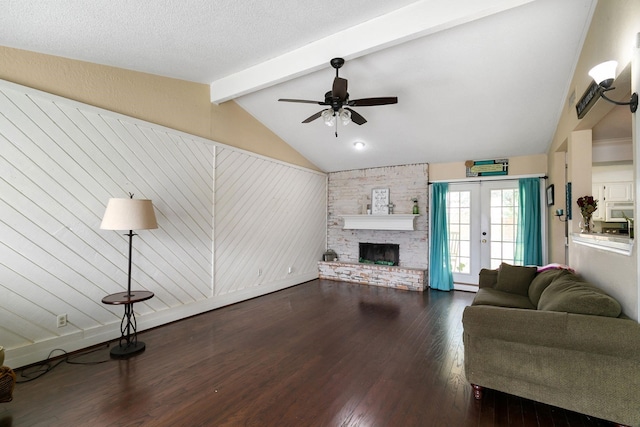 living room featuring ceiling fan, french doors, dark wood-type flooring, a stone fireplace, and lofted ceiling with beams