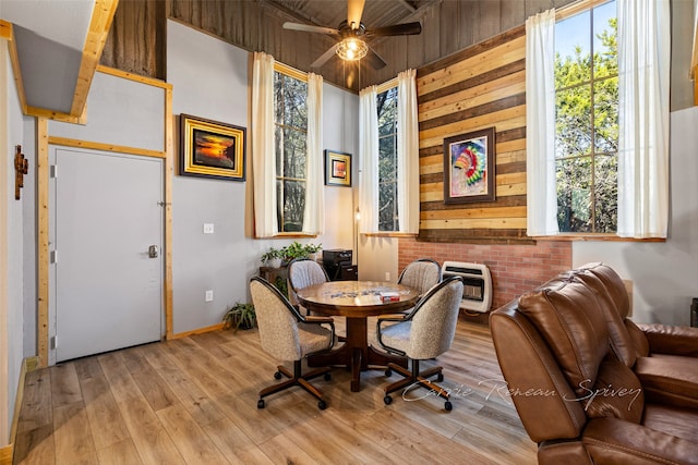 dining area with heating unit, light hardwood / wood-style floors, and ceiling fan