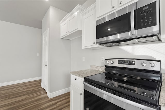 kitchen featuring white cabinets, dark hardwood / wood-style flooring, light stone countertops, and stainless steel appliances