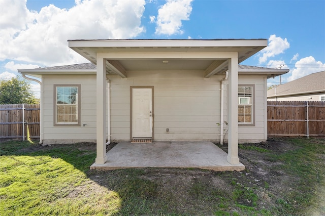 rear view of house featuring a patio area and a yard