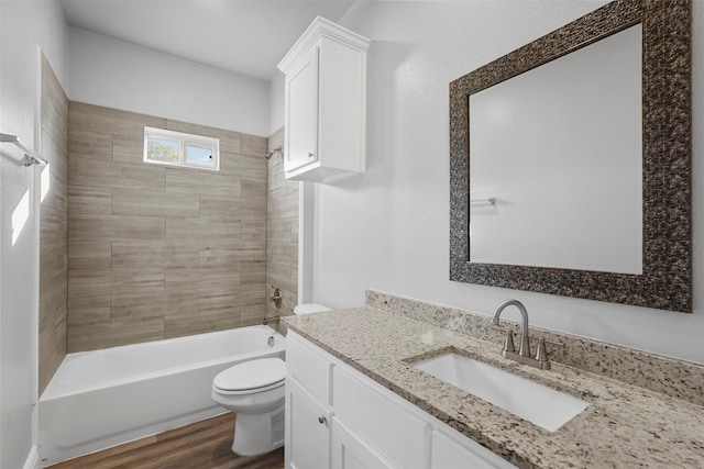 full bathroom with vanity, wood-type flooring, tiled shower / bath combo, and toilet