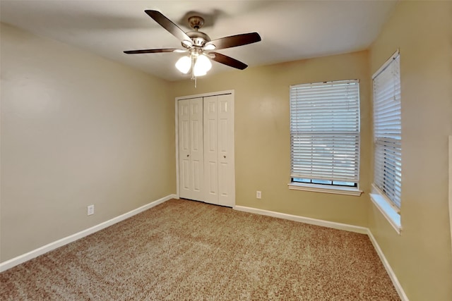 unfurnished bedroom with ceiling fan, a closet, and light colored carpet