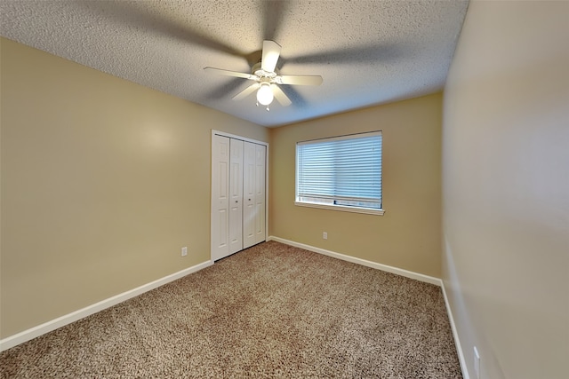 unfurnished bedroom featuring carpet flooring, ceiling fan, a closet, and a textured ceiling