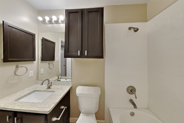 full bathroom with vanity, tiled shower / bath combo, and toilet