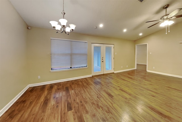 spare room featuring french doors, ceiling fan with notable chandelier, hardwood / wood-style flooring, and lofted ceiling