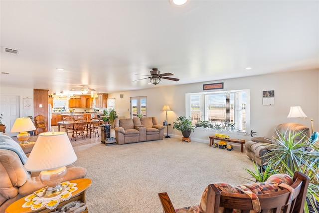 living room with ceiling fan and carpet