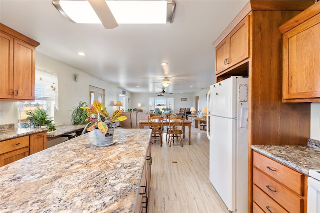 kitchen with plenty of natural light, white fridge, ceiling fan, and light hardwood / wood-style flooring