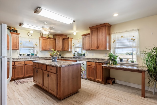 kitchen featuring ceiling fan, white fridge, dishwasher, a center island, and light hardwood / wood-style floors