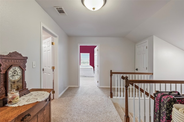 corridor featuring light carpet and vaulted ceiling