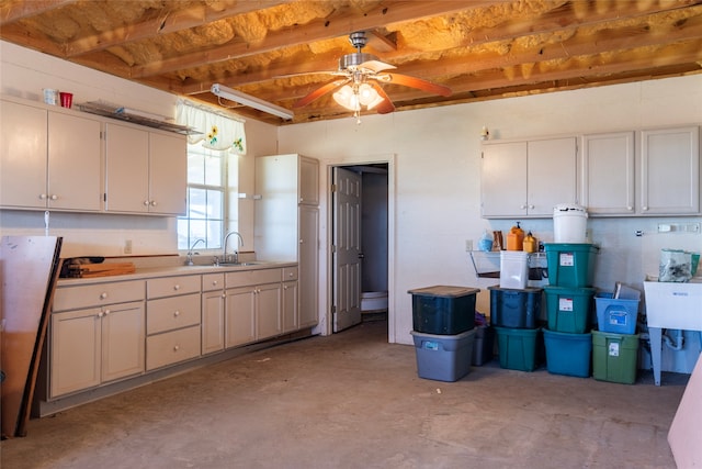 kitchen with ceiling fan, sink, white cabinets, and beamed ceiling