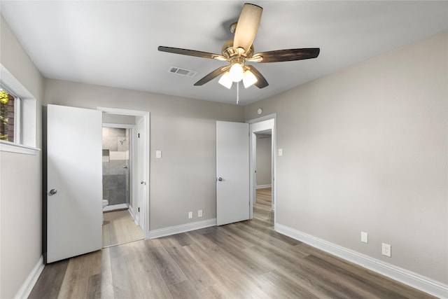 unfurnished bedroom with connected bathroom, ceiling fan, and light hardwood / wood-style flooring