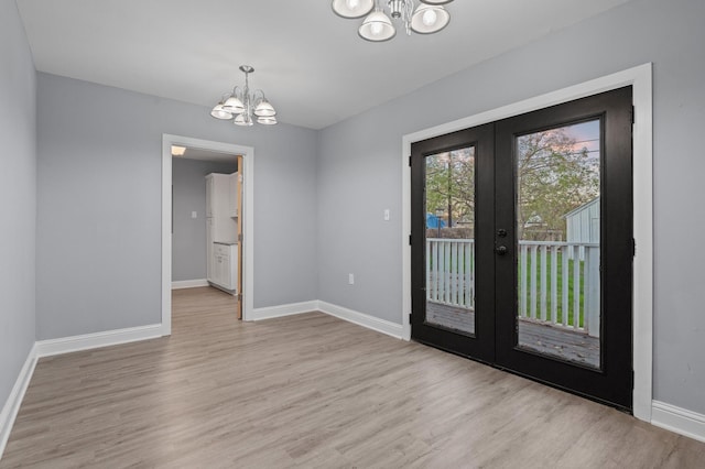 interior space featuring a notable chandelier, light hardwood / wood-style flooring, and french doors