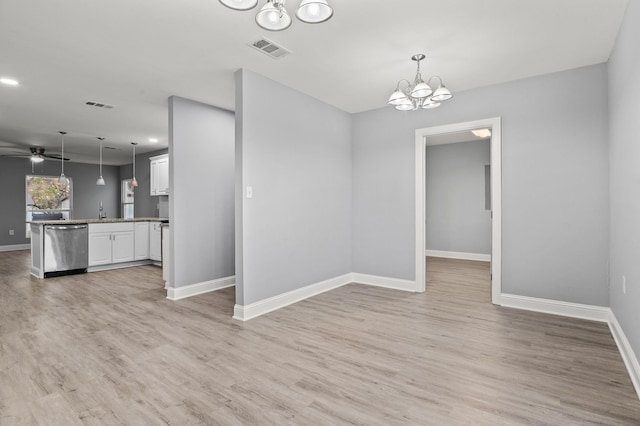 interior space featuring ceiling fan with notable chandelier, sink, and light hardwood / wood-style flooring