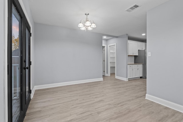 interior space with a chandelier and light hardwood / wood-style flooring