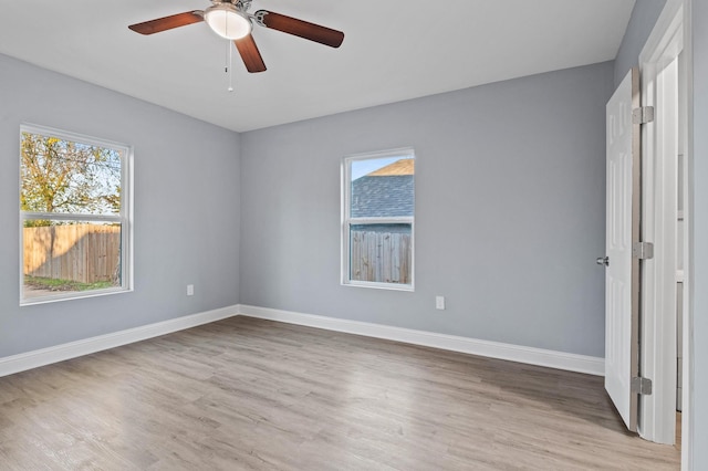 empty room with ceiling fan and light hardwood / wood-style flooring