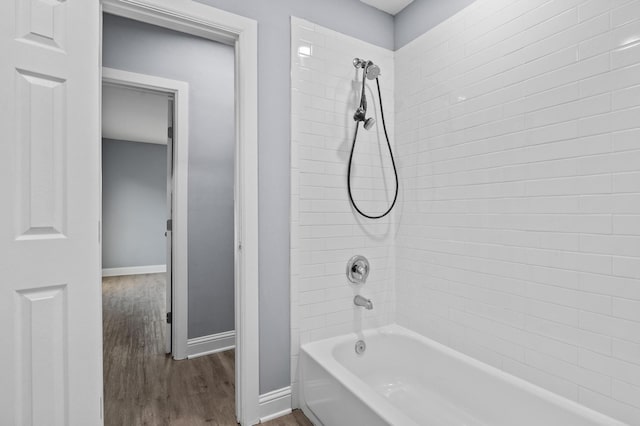 bathroom with tiled shower / bath combo and hardwood / wood-style flooring