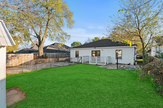 back of house with a wooden deck and a lawn