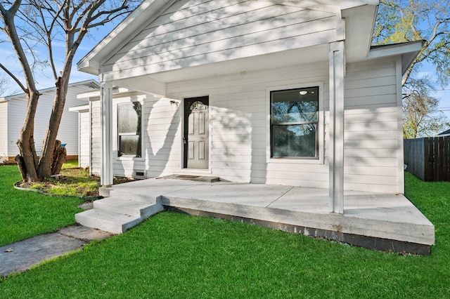 entrance to property with a lawn and a porch