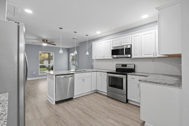 kitchen with white cabinets, light hardwood / wood-style floors, kitchen peninsula, and stainless steel appliances