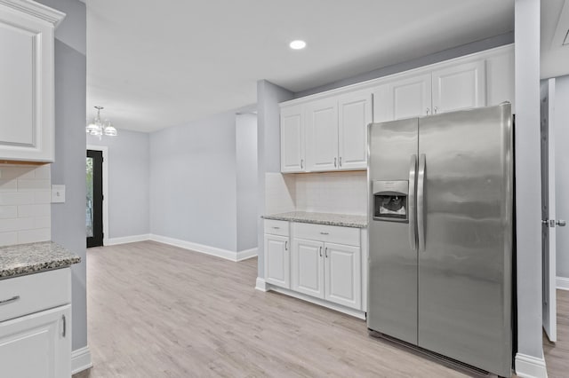 kitchen with white cabinetry, stainless steel fridge with ice dispenser, and tasteful backsplash